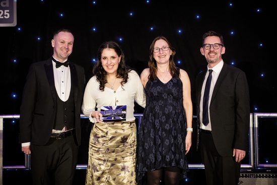 4 people pose with an award
