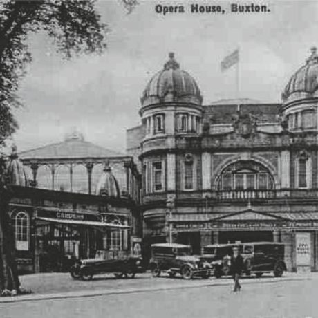 Black and white: Exterior of the opera house with early 1900's cars parked out side
