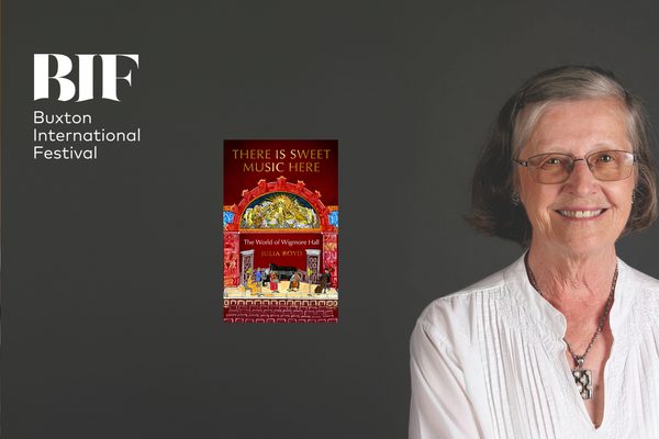 To the right, an old woman with short, brunette hair is wearing glasses, statement jewellery and a white blouse while smiling directly at the camera against a grey backdrop, a book titled 'There Is Sweet Music Here' by Julia Boyd lies off centre.