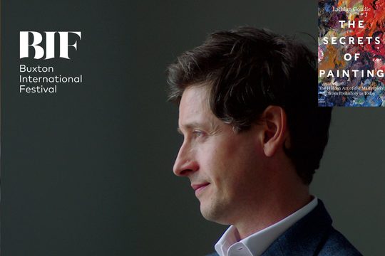 The side profile of a man with brunette hair lies off centre, he is wearing a white shirt and a navy blazer against a grey backdrop, a book titled 'The Secrets of Painting' by Lachlan Goudie sits in the top right-hand corner.