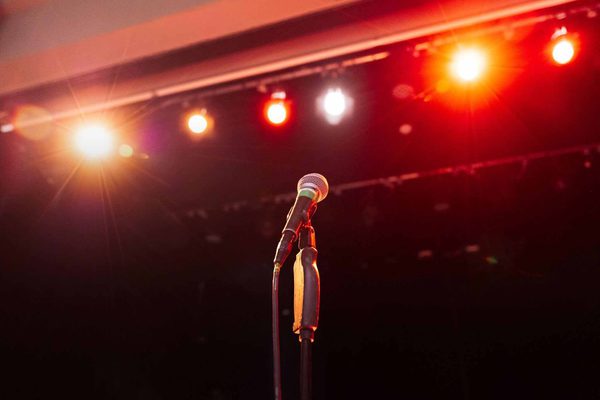 A microphone with stage lights in the background.